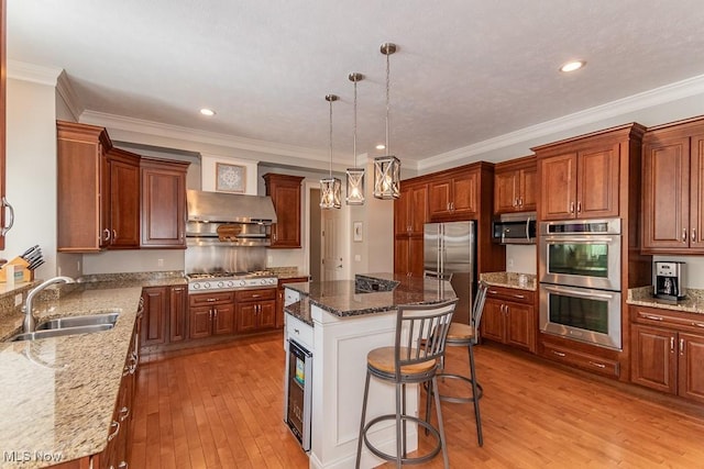 kitchen featuring light wood-style floors, appliances with stainless steel finishes, a sink, and a center island