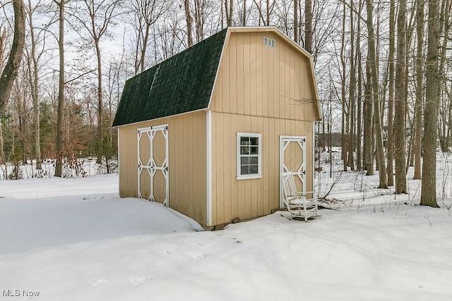 snow covered structure with an outdoor structure and a barn