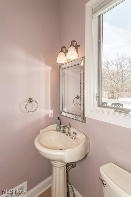 bathroom featuring baseboards and toilet