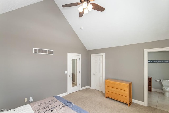 bedroom with light carpet, baseboards, visible vents, connected bathroom, and high vaulted ceiling