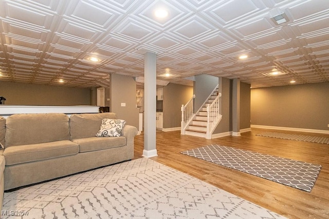 unfurnished living room featuring an ornate ceiling, stairway, baseboards, and wood finished floors