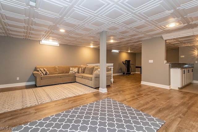 living room with an ornate ceiling, baseboards, and wood finished floors