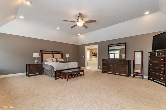 bedroom with ensuite bath, baseboards, and vaulted ceiling