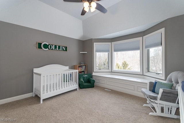 bedroom featuring lofted ceiling, light carpet, a ceiling fan, baseboards, and a crib