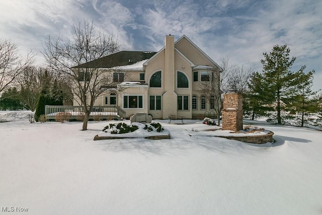 view of front of home with a chimney and stucco siding