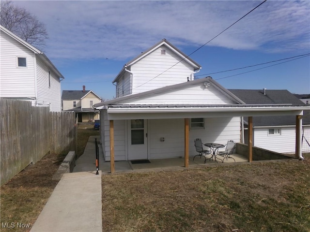 back of property with a patio area and fence