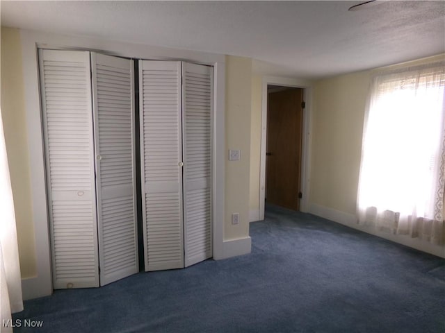 unfurnished bedroom with carpet floors, a closet, and baseboards