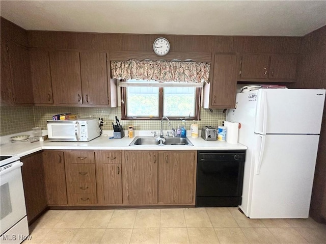 kitchen featuring white appliances, light countertops, a sink, and decorative backsplash