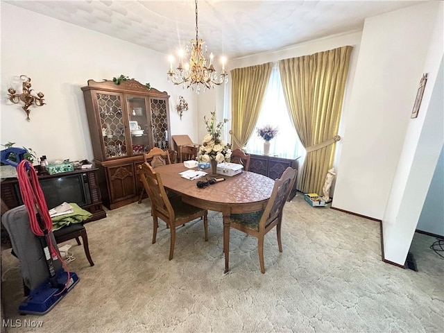 dining space with light carpet, baseboards, and a notable chandelier