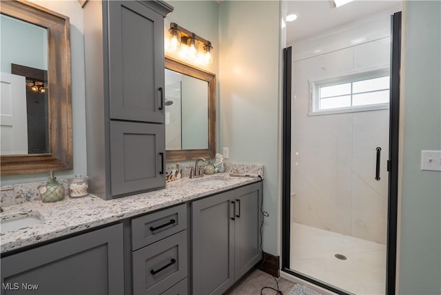 full bath featuring double vanity, a shower stall, and a sink