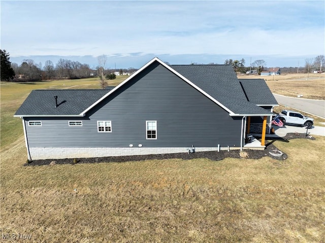 view of property exterior featuring a yard and a shingled roof