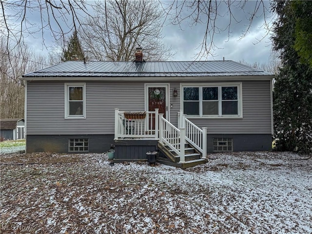 view of front of house featuring a chimney and metal roof