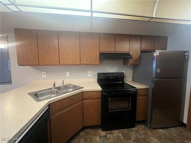 kitchen with dishwasher, freestanding refrigerator, under cabinet range hood, black range with electric cooktop, and a sink