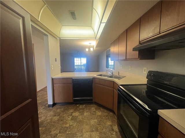 kitchen featuring visible vents, under cabinet range hood, light countertops, black appliances, and a sink