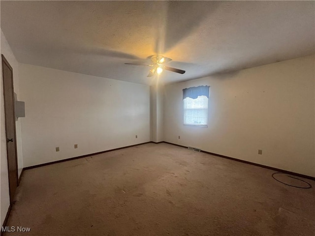 unfurnished room with ceiling fan, light carpet, visible vents, and baseboards