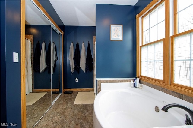 bathroom with a bath and a wealth of natural light