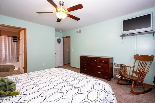 carpeted bedroom featuring a ceiling fan, visible vents, baseboards, and ensuite bathroom