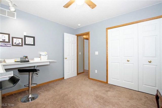 carpeted home office featuring baseboards, visible vents, and a ceiling fan