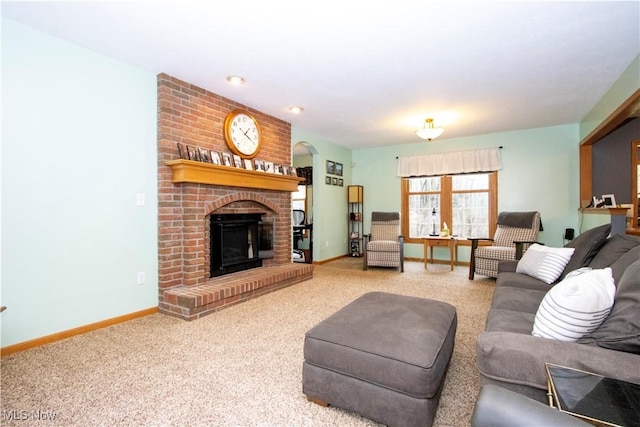 carpeted living room featuring a brick fireplace and baseboards