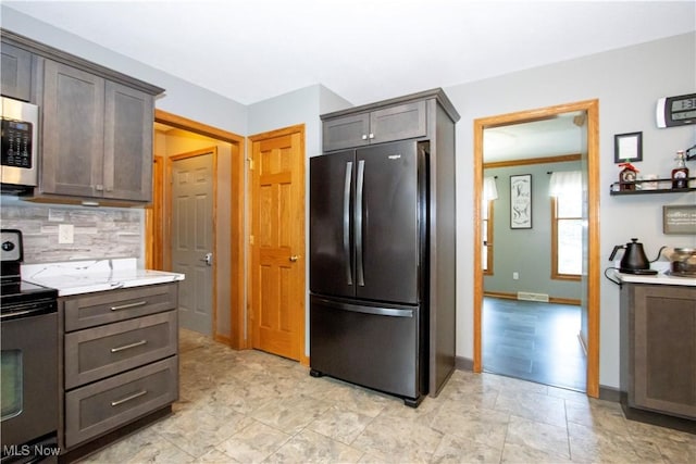 kitchen with baseboards, electric stove, light countertops, freestanding refrigerator, and decorative backsplash