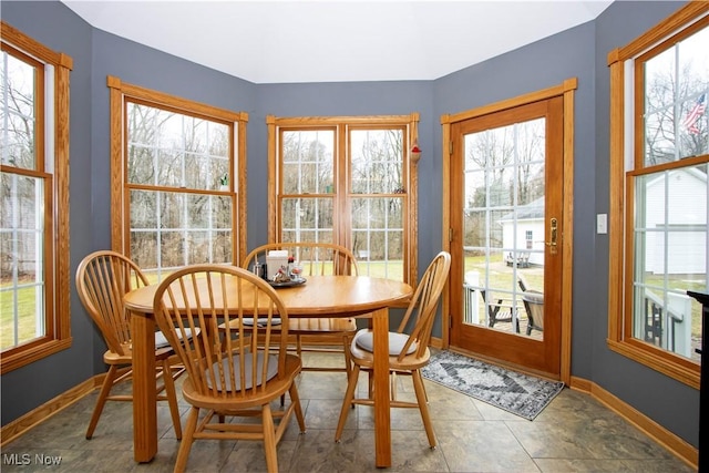 tiled dining room with plenty of natural light and baseboards