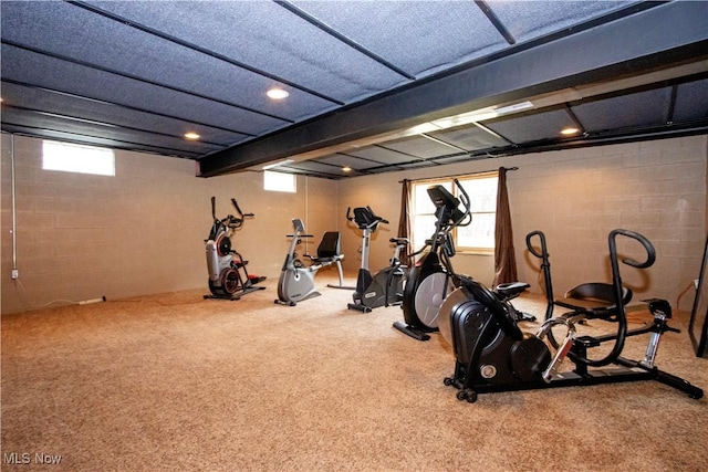 exercise room with concrete block wall, a wealth of natural light, carpet flooring, and recessed lighting