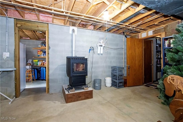 unfinished below grade area featuring a wood stove