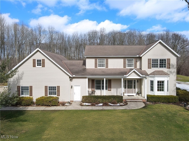 traditional-style house featuring a porch and a front yard