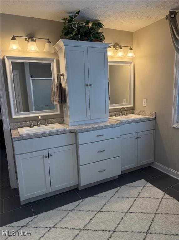 full bathroom featuring tile patterned flooring, a textured ceiling, and vanity