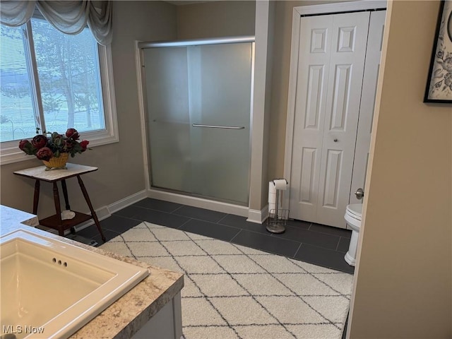 full bathroom featuring a stall shower, a closet, and tile patterned floors