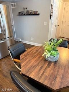 dining space with visible vents, baseboards, and wood finished floors