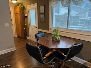 dining space with baseboards, dark wood finished floors, and a wealth of natural light