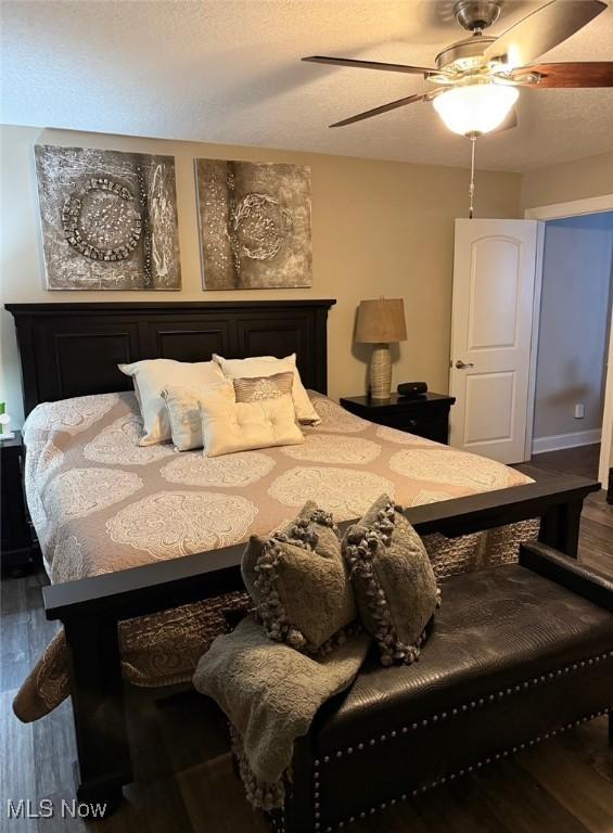 bedroom featuring a textured ceiling, wood finished floors, and a ceiling fan