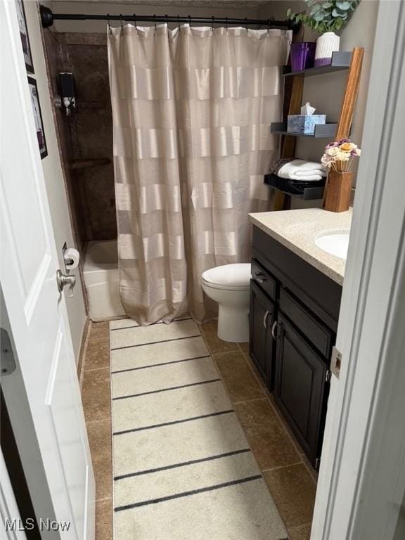 full bath featuring shower / tub combo, tile patterned flooring, vanity, and toilet