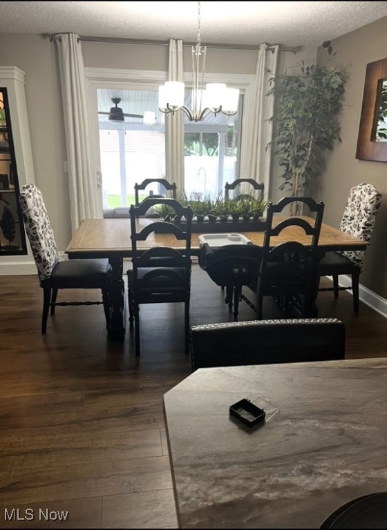 dining room featuring baseboards, a chandelier, dark wood finished floors, and a textured ceiling