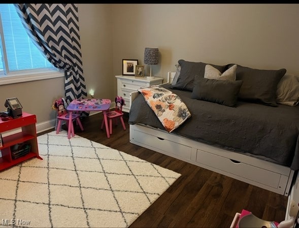 bedroom with baseboards and wood finished floors