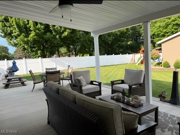 view of patio featuring a playground, ceiling fan, a fenced backyard, and an outdoor hangout area