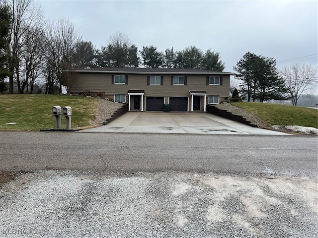 view of front of home with a garage, driveway, and a front yard