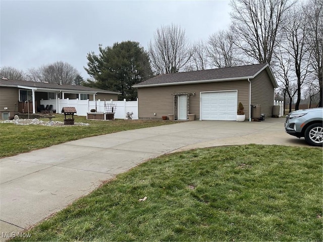 view of side of home with a garage, concrete driveway, a yard, and fence