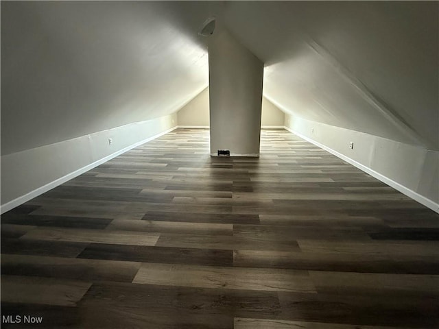 bonus room with baseboards, vaulted ceiling, and dark wood finished floors