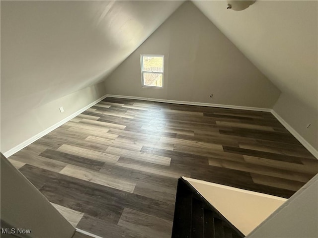 bonus room with lofted ceiling, baseboards, and wood finished floors