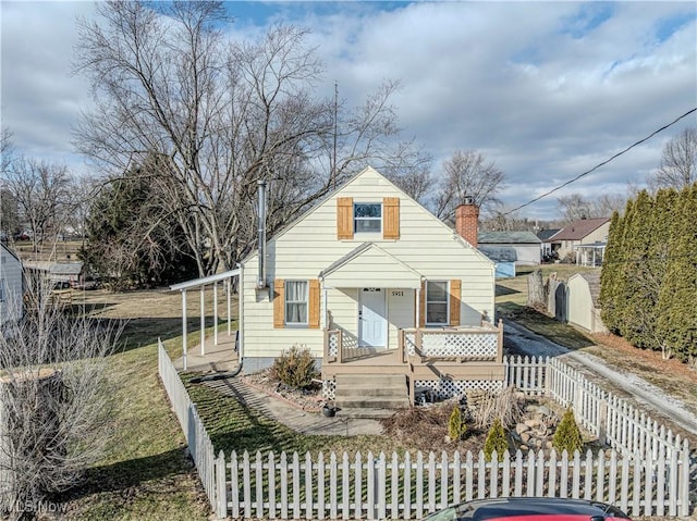 bungalow-style house with a fenced front yard and a chimney