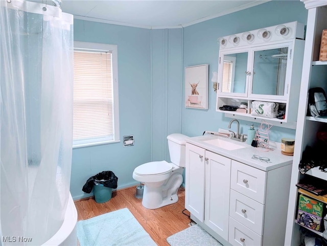 bathroom with crown molding, curtained shower, toilet, vanity, and wood finished floors