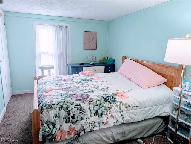 carpeted bedroom with baseboards and a textured ceiling