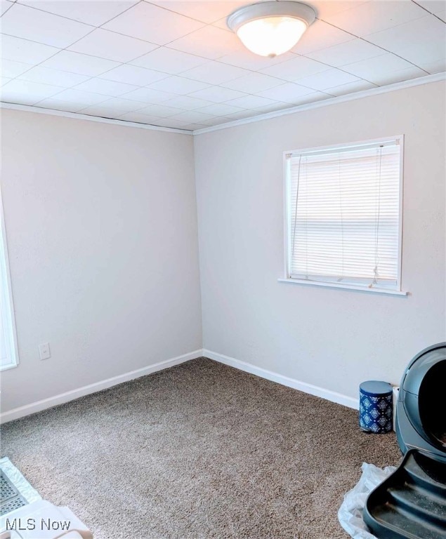 carpeted spare room featuring ornamental molding and baseboards