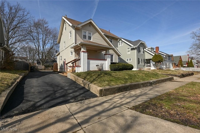 view of front of home featuring a residential view, fence, and brick siding