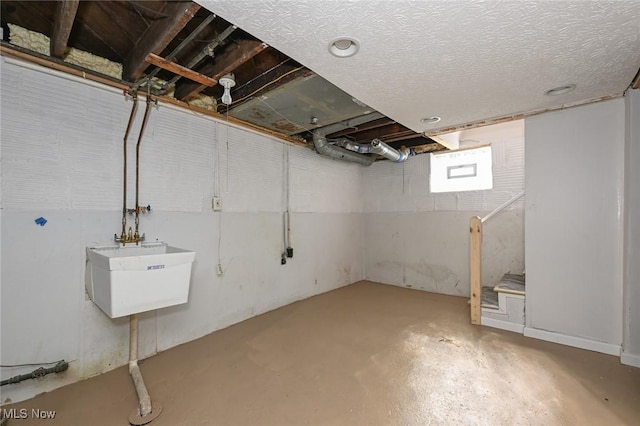 basement featuring a textured ceiling and a sink