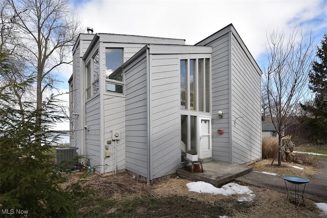 exterior space with a chimney and central AC