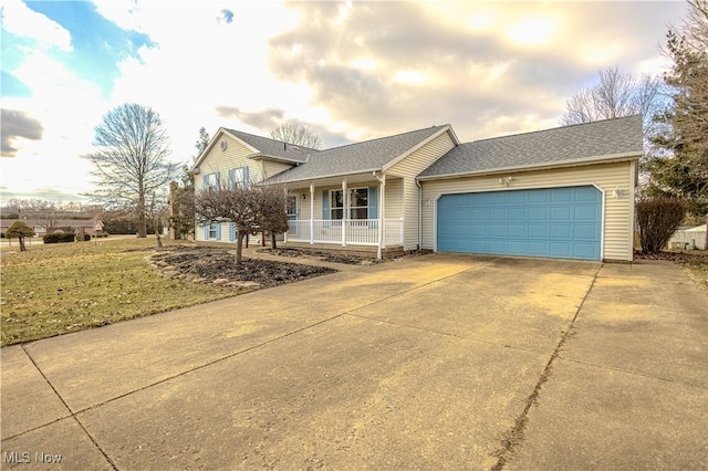 split level home featuring driveway, a shingled roof, a garage, and a porch