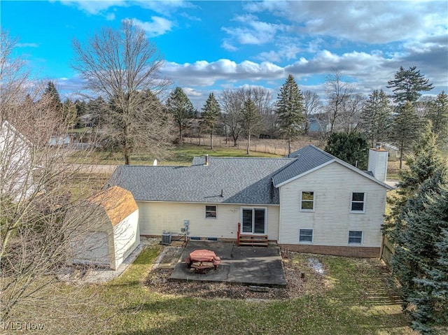 rear view of property featuring entry steps, central AC, roof with shingles, a chimney, and a patio area